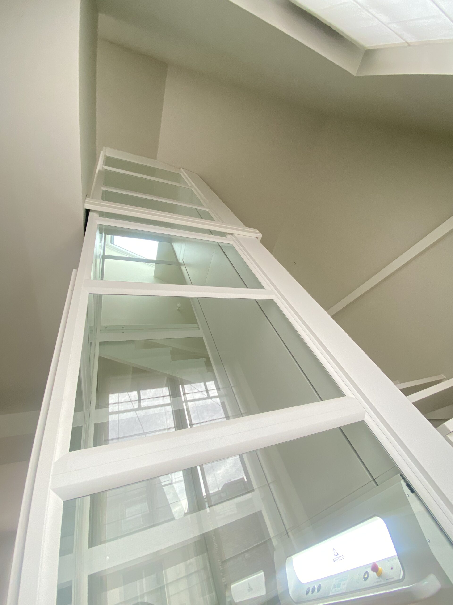 Contre-plongée sur monte-charge architectural intégrant un escalier, pour l'accessibilité PMR