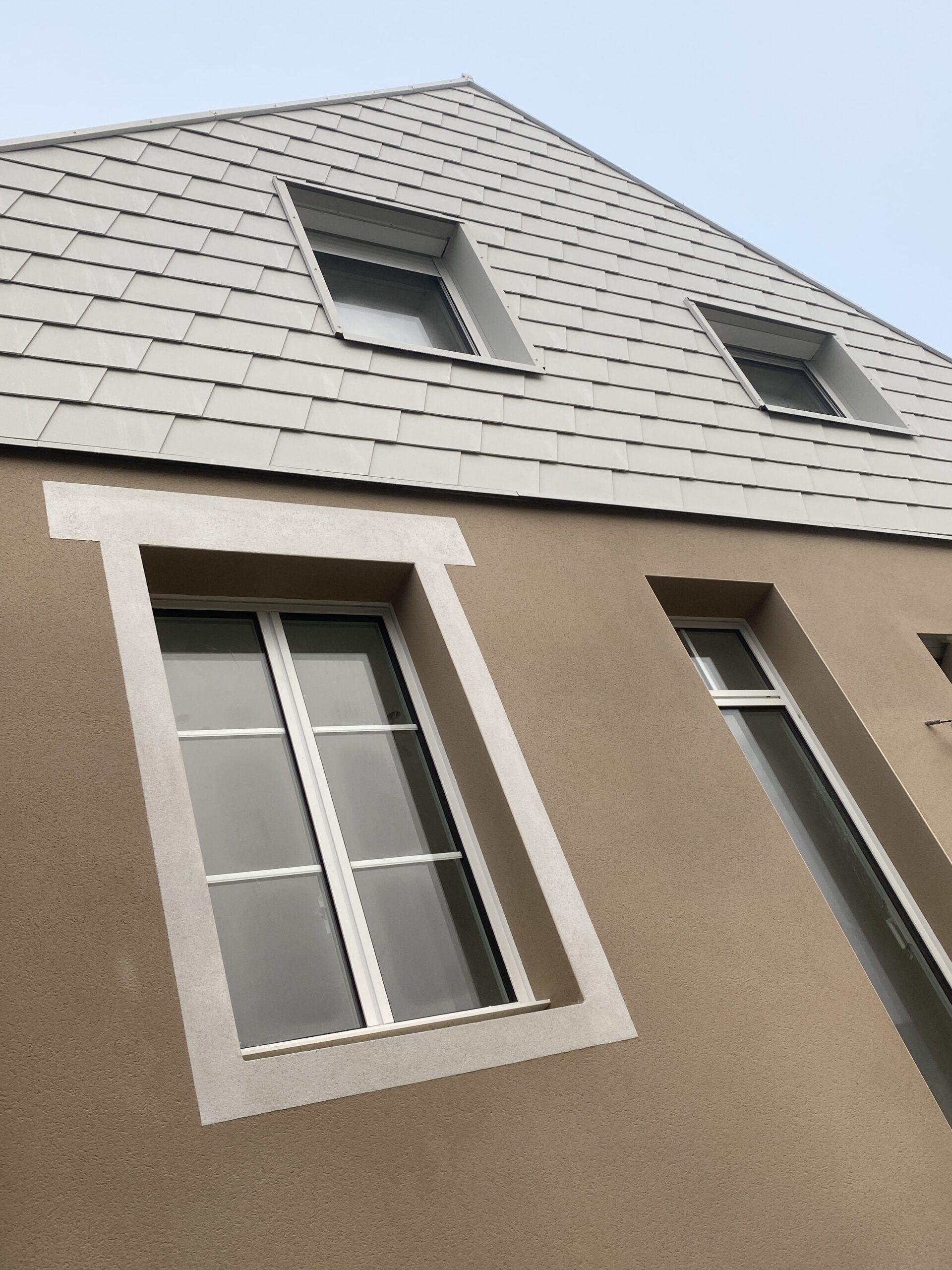 Rénovation d'une maison contemporaine en pierre réaliser par Phenome, architecte à Rennes. Plan large sur la façade.