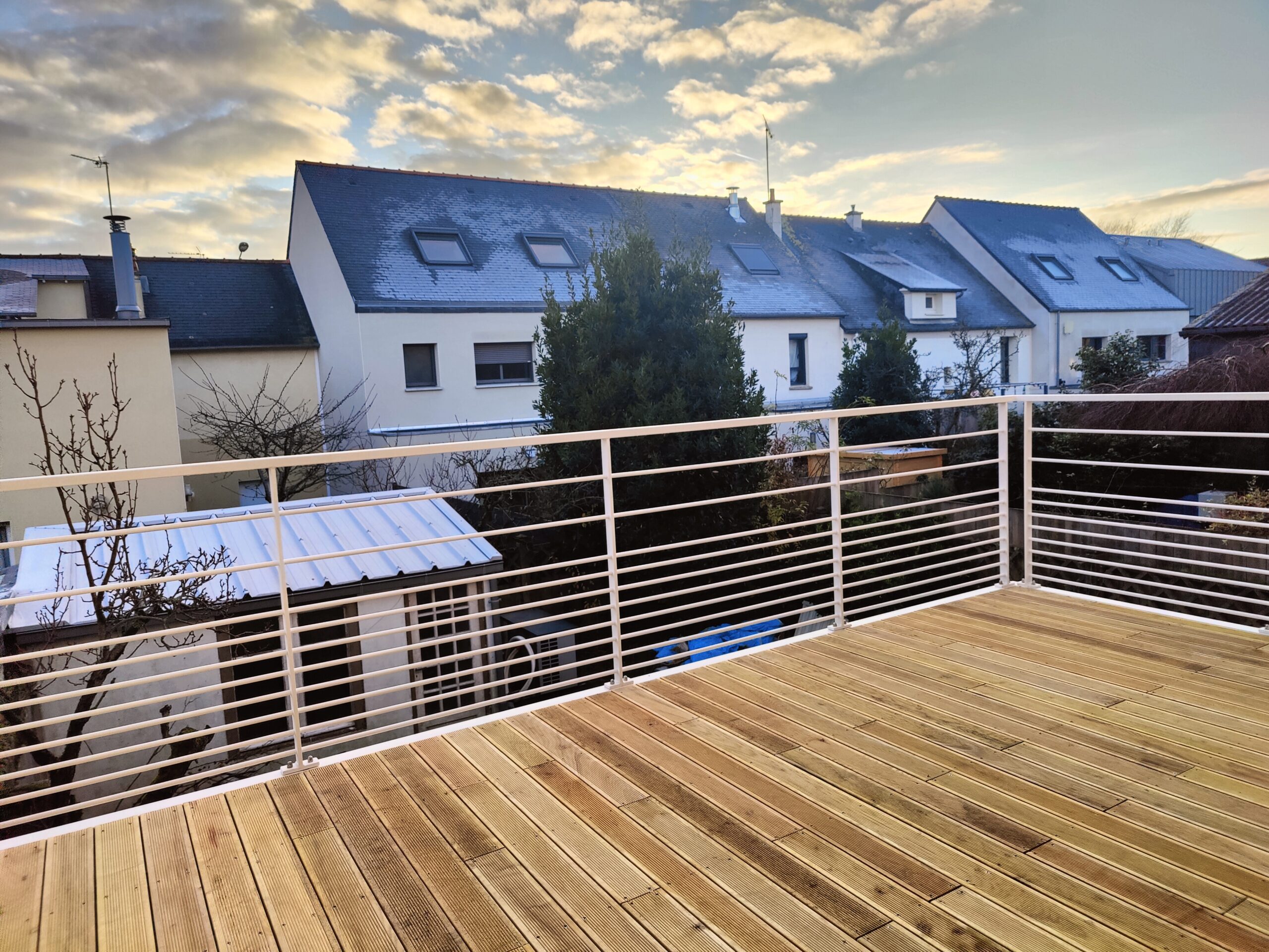 Aménagement extérieur moderne : grande terrasse surélevé en bois IPE et garde-corps horizontal blanc.